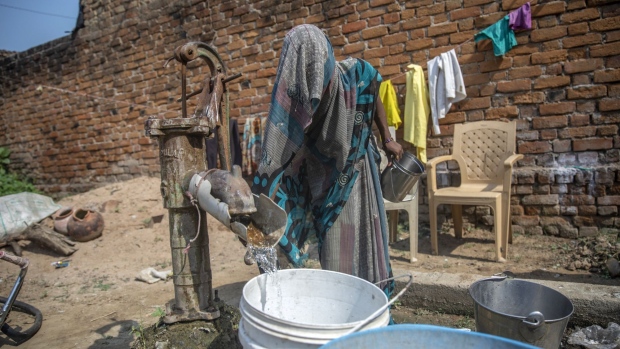 A woman collects water from a pump at a village in Banda District, Uttar Pradesh, India, on Sunday, Oct. 11, 2020. Covid-19 is exposing India's big divides, like access to quality health care, proper sanitation and who gets to eat, and who doesn't. Even before the lockdowns, roughly three-quarters of the population (more than 1 billion people) couldn't afford a healthy diet.
