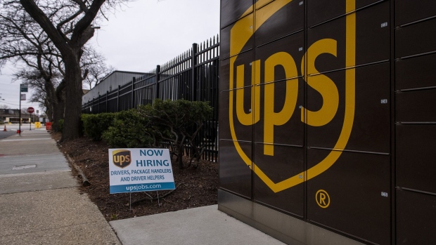 A "Now Hiring" sign outside a United Parcel Service Inc. (UPS) distribution center in Chicago, Illinois, U.S., on Monday, Nov. 30, 2020. Online shoppers in the U.S. are expected to drop a record-busting $12.7 billion on Cyber Monday -- the busiest e-commerce day of the year -- presenting a valuable opportunity for retailers whose websites, customer service departments and delivery operations can withstand the period of crushing traffic. Photographer: Christopher Dilts/Bloomberg