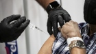A person receives a dose of the Covid-19 vaccination at the New Jersey Convention and Exposition Center in Edison, New Jersey, U.S., on Friday, Jan. 15, 2021. New Jersey will expand Covid-19 vaccinations to people 65 years old and over and those ages 16 to 64 who have "health challenges," Murphy said. Photographer: Mark Kauzlarich/Bloomberg