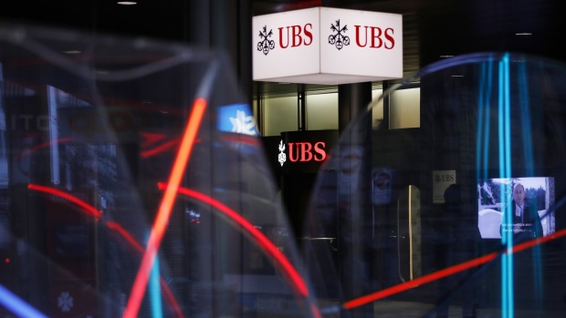 Illuminated UBS Group AG logos outside the company's headquarters in Zurich, Switzerland, on Tuesday, Jan. 26, 2020. UBS plans to buy back as much as 4 billion francs ($4.5 billion) of shares over the next three years, bolstering shareholder returns after income from managing client assets and investment banking propelled gains at the world’s largest wealth manager. Photographer: Stefan Wermuth/Bloomberg