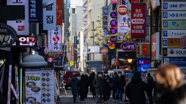 Pedestrians wearing protective mask walk through the street in the Jongno district of Seoul, South Korea, on Tuesday, Jan. 19, 2021. South Korea will impose a “special quarantine period” for two weeks from Feb. 2 in the run-up to the Lunar New Year holidays to prevent another wave of infections.
