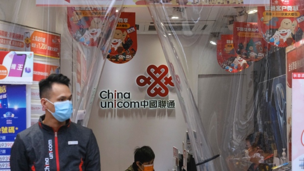 Sales assistants work at a China Unicom Hong Kong Ltd. store in Hong Kong, China, on Monday, Jan. 4, 2021. China's state-owned telecommunications companies declined in Hong Kong after the New York Stock Exchange said it's delisting them to comply with a U.S. executive order that sanctioned companies identified as affiliated with the Chinese military.