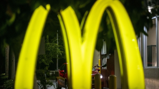 A customer receives an order from a worker at the drive-thru of a McDonald's Corp. restaurant in El Segundo, California, U.S., on Monday, April 27, 2020. McDonald's is cutting capital expenditures and suspending buybacks as the coronavirus pandemic gnawed at sales. Photographer: Kyle Grillot/Bloomberg