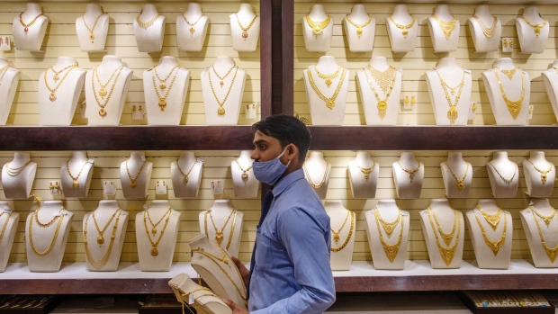 An employee arranges gold necklaces inside a Kalyan Jewellers store during the festival of Dhanteras in Noida, India, on Friday, Nov. 13, 2020. India's main holiday season -- culminating Saturday with Diwali, the festival of lights -- appears to be giving a much needed boost to demand, with online retail sales to business activity indicators signalling Asias third-largest economy is recovering.