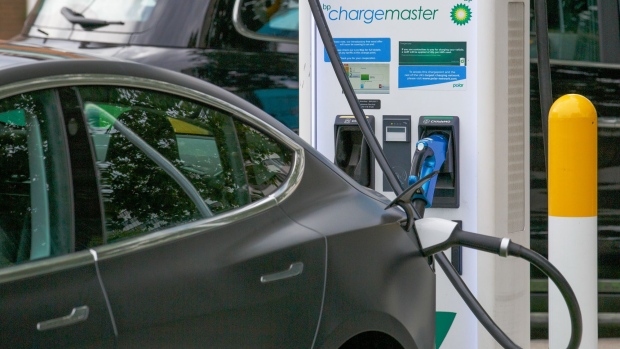 An electronic automobile, manufactured by Tesla Inc. charges at a BP Plc petrol and refueling station in London, U.K., on Tuesday, Aug. 4, 2020. BP Plc cut its dividend for the first time in a decade, removing a cornerstone of its investment case after the coronavirus pandemic upended almost every aspect of its business.