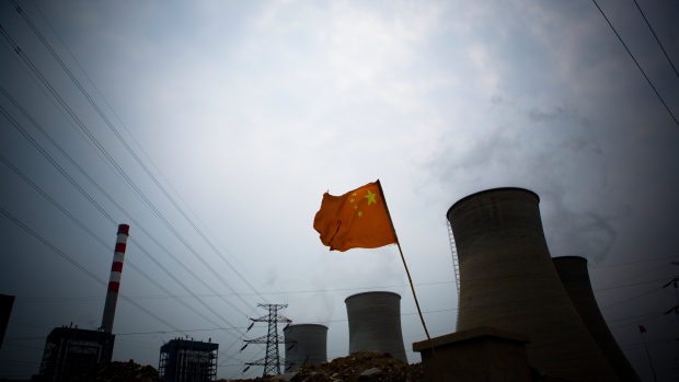 TIANJIN, CHINA - JULY 20: A Chinese flag flies in front of a coal fired power plant rising across the skyline of rapidly China, while fears of widespread industrial pollution mount on July 20, 2007 in Tianjin, China. (Photo by Jeff Hutchens/Getty Images)