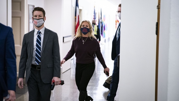 Representative Marjorie Taylor Green, a Republican from Georgia, center, wears a protective mask while arriving back to her office after speaking on the House floor at the Longworth House Office building on Capitol Hill in Washington, D.C., U.S., on Thursday, Feb. 4, 2021. House Democrats are heading into a showdown with Republicans today over GOP Representative Marjorie Taylor Greene's past promotion of conspiracies that threatens to provoke an escalating cycle of political retaliation. Photographer: Al Drago/Bloomberg
