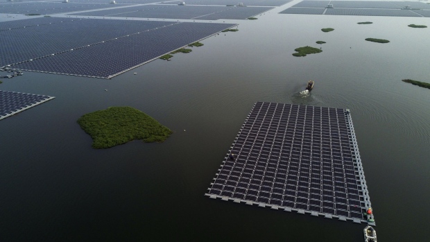 HUAINAN, CHINA - JUNE 14: A boat pulls a group of solar panels to be connected to a large floating solar farm project under construction by the Sungrow Power Supply Company on a lake caused by a collapsed and flooded coal mine on June 14, 2017 in Huainan, Anhui province, China. The floating solar field, billed as the largest in the world, is built on a part of the collapsed Panji No.1 coal mine that flooded over a decade ago due to over-mining, a common occurence in deep-well mining in China's coal heartland. When finished, the solar farm will be made up of more than 166,000 solar panels which convert sunlight to energy, and the site could potentially produce enough energy to power a city in Anhui province, regarded as one of the country's coal centers. Local officials say they are planning more projects like it, marking a significant shift in an area where long-term intensive coal mining has led to large areas of subsidence and environmental degradation. However, the energy transition has its challenges, primarily competitive pressure from the deeply-established coal industry that has at times led to delays in connecting solar projects to the state grid. China's government says it will spend over US $360 billion on clean energy projects by 2020 to help shift the country away from a dependence on fossil fuels, and earlier this year, Beijing canceled plans to build more than 100 coal-fired plants in a bid to ease overcapacity and limit carbon emissions. Already, China is the leading producer of solar energy, but it also remains the planet's top emitter of greenhouse gases and accounts for about half of the world's total coal consumption. (Photo by Kevin Frayer/Getty Images)