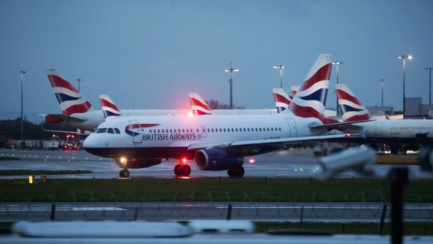 A passenger aircraft operated by British Airways, a unit of International Consolidated Airlines Group SA, on the runway at London Heathrow Airport Ltd. in London, U.K., on Saturday, Dec. 19, 2020. The pandemic has put a third of all tourism jobs at risk, and airlines around the world have said they need as much as $200 billion in bailouts. Photographer: Chris Ratcliffe/Bloomberg