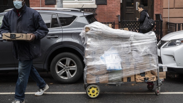 A worker carries Amazon packages during a delivery in New York, U.S., on Tuesday, Oct. 13, 2020. Amazon.com Inc.'s two-day Prime Day sale kicks off on Tuesday and is expected to give the world's largest e-commerce company an early advantage over brick-and-mortar rivals still contending with pandemic-spooked consumers wary of battling Black Friday crowds. Photographer: Victor J. Blue/Bloomberg