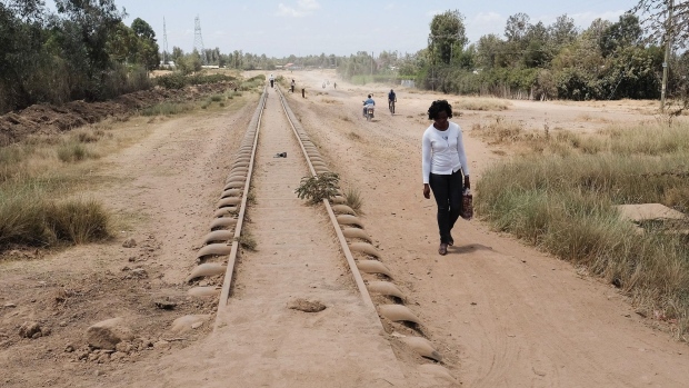 NANYUKI, KENYA - FEBRUARY 25: A woman walks alongside a railway line on February 25, 2016 in Nanyuki, Kenya. Situated in East Africa with a coastline on the Indian Ocean Kenya encompasses savannah, lakelands, the dramatic Great Rift Valley, mountain highlands and abundant wildlife such as lions, elephants and rhinos. From Nairobi, the capital, safaris visit the Maasai Mara reserve, known for its annual wildebeest migrations, and Amboseli National Park, offering views of Tanzania's 5,895m Mt. Kilimanjaro. Kenya gained its independence from British colonial rule in 1963 after an insurrection led by Jomo Kenyatta. (Photo by Ian Forsyth/Getty Images) Photographer: Ian Forsyth/Getty Images Europe