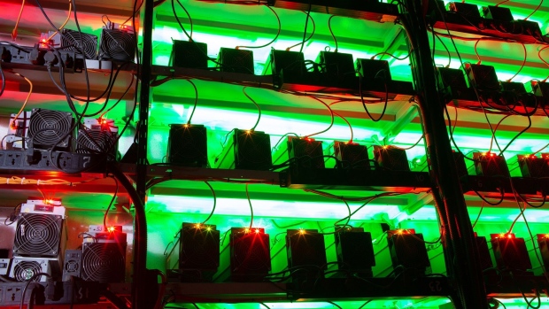 Illuminated racks of application-specific integrated circuit (ASIC) mining devices and power units at the BitCluster cryptocurrency mining farm in Norilsk, Russia, on Sunday, Dec. 20, 2020. Norilsk may soon be famous for a different type of mining — it now hosts the Arctic's first crypto farm for producing new Bitcoins. Photographer: Andrey Rudakov/Bloomberg