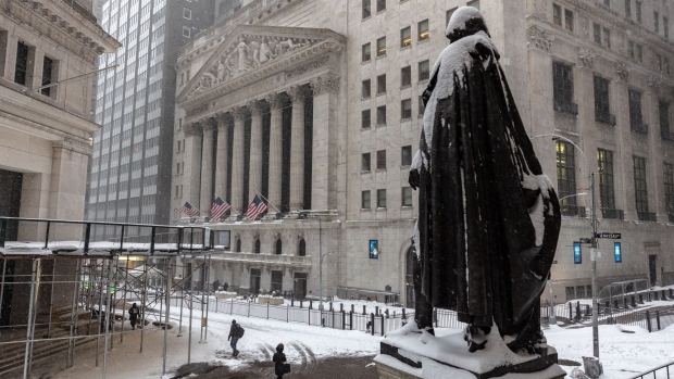 Pedestrians pass in front of the New York Stock Exchange (NYSE) in New York, U.S. Photographer: Jeenah Moon/Bloomberg