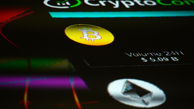The symbols for Bitcoin and Ethereum cryptocurrency sit displayed on a screen. Photographer: Mary Turner/Bloomberg