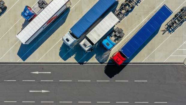 Trucks and trailers sit parked at the Kuehne + Nagel International AG logistics center in this aerial view in Haiger, Germany, on Thursday, Aug. 6, 2020. Transport group Kuehne + Nagel’s first-half earnings beat estimates, aided by cost management as its revenue declined. Photographer: Alex Kraus/Bloomberg