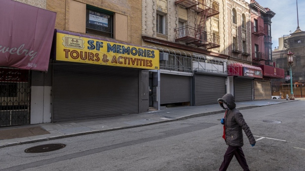 A pedestrian wearing a protective mask walks past closed stores on Grant Avenue in San Francisco, California, U.S., on Tuesday, Dec. 29, 2020. Governor Newsom said Monday he expected to extend the strict regional stay-at-home orders for the hard-hit regions of the state where Covid-19 hospitalizations are still rising, The San Francisco Chronicle reported. Photographer: David Paul Morris/Bloomberg