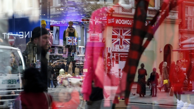 The window of a Gap Inc. fashion store reflects the British Union flag, also known as a Union Jack, signage of a tourist gift store in London, U.K, on Thursday, Oct. 31, 2019. In the lead-up to the vote, “both Labour and the Conservatives are expected to come out with pretty punchy views on tax, innovation and public spending, which could have significant implications for both corporates and consumers,” Emma Wall, head of investment analysis at stockbroker Hargreaves Lansdown Plc, said by email. Photographer: Hollie Adams/Bloomberg