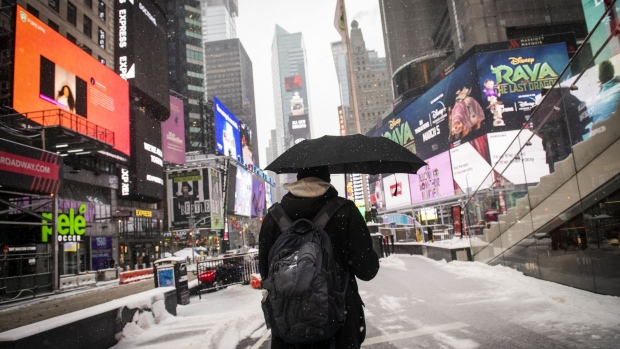 A pedestrian carries an umbrella while walking through the Times Square area during a winter storm in New York, U.S., on Thursday, Feb. 18, 2021. A meandering storm will leave New York and the Northeast with up to 8 inches (20 centimeters) of snow through Friday, while ice and cold continue to plague Texas. Photographer: Mark Kauzlarich/Bloomberg