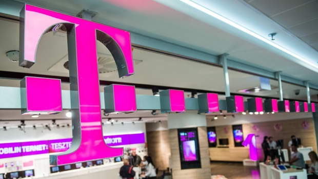 Customers browse mobile phone handsets as a sign sits above the entrance to a T-Mobile store, operated by Magyar Telekom Nyrt., in Budapest, Hungary, on Monday, Nov. 2, 2015. Magyar Telekom will announce third-quarter earnings on Wednesday.