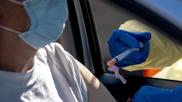 A healthcare worker administers a dose of the Moderna Covid-19 vaccine at a drive-thru vaccination site at the Auto Club Speedway in Fontana, California, U.S., on Tuesday, Feb. 2, 2021. Appointments quickly filled up Monday morning for the "super site event" in Fontana, officials said. Photographer: Kyle Grillot/Bloomberg