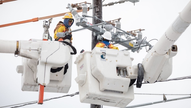 Workers repair a power line in Austin, Texas on Feb. 18. Photographer: Thomas Ryan Allison/Bloomberg