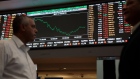 People pass by an electronic board displaying stock activity at the Brasil Bolsa Balcao (B3) stock exchange in Sao Paulo, Brazil, on Thursday, March 21, 2019. Brazil's Ibovespa Index fell Thursday following the arrest of former Brazilian president Michel Temer as part of the Carwash corruption probe that's ensnared some of the country's top business executives and politicians. Photographer: Patricia Monteiro/Bloomberg