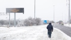 A pedestrian walks past a road sign warning commuters of icy conditions on a road in Austin, Texas, U.S., on Thursday, Feb. 18, 2021. Texas is restricting the flow of natural gas across state lines in an extraordinary move that some are calling a violation of the U.S. Constitution’s commerce clause. Photographer: Thomas Ryan Allison/Bloomberg