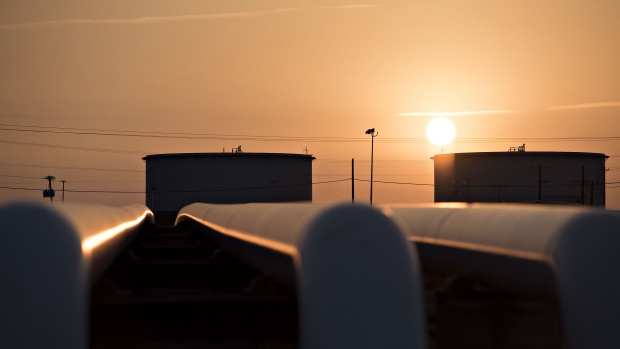 The sun rises beyond oil storage tanks at the Enbridge Inc. Cushing storage terminal in Cushing, Oklahoma. U.S. drillers have idled 58 percent of the oil rigs that were operating in October, according to Baker Hughes Inc. Photographer: Daniel Acker