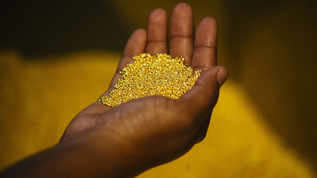 A worker holds a handful of gold bullion granules during manufacture at the Rand Refinery Ltd. plant in Germiston, South Africa, on Wednesday, Aug. 16. 2017. Established by the Chamber of Mines of South Africa in 1920, Rand Refinery is the largest integrated single-site precious metals refining and smelting complex in the world, according to their website.