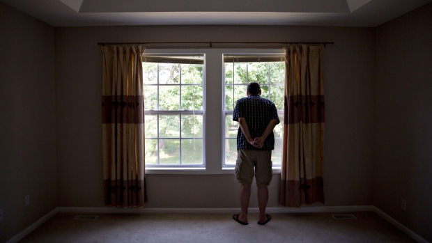 A prospective home buyer looks out the master bedroom window at a house for sale in Dunlap, Illinois.