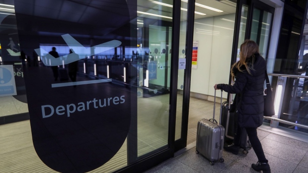 A passenger enters the departures area for terminal 2 at London Heathrow Airport in London, U.K., on Friday, Dec. 23, 2016. Planned strikes by British Airways cabin crew on Christmas Day and Boxing Day have been suspended, PA reports, citing the union Unite. Photographer: Chris Ratcliffe/Bloomberg