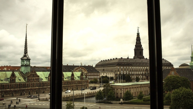 The old stock exchange building, left, also known as Borsbygningen, and Christiansborg Palace, right, sit on the city skyline seen from the headquarters of the Danish central bank in Copenhagen, Denmark, on Wednesday, Sept. 13, 2017. "We have previously seen that the economy can overheat vigorously and suddenly when it is booming, Denmark's Central Bank Governor Lars Rohde said in a statement on Wednesday. Photographer: Bloomberg/Bloomberg