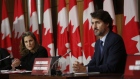 Chrystia Freeland speaks alonside Justin Trudeau at an Ottawa news conference.