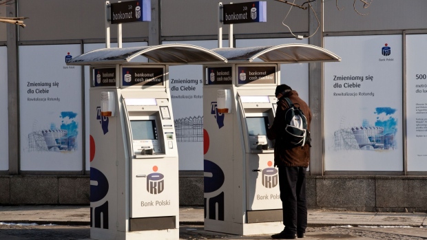 A customer uses a freestanding automated teller machine operated by PKO Bank Polski SA on a street in Warsaw. Photographer: Piotr Malecki/Bloomberg