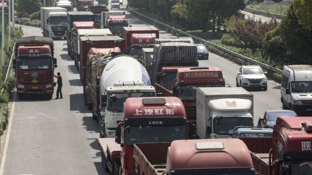 Trucks and semi-trailers wait in line on a highway leading into the city in Shanghai, China, on Friday, April 24, 2020. China is studying ways that it could accelerate purchases of U.S. farm goods to meet its phase-one trade deal commitments after the coronavirus delayed some imports, according to people familiar with the matter. Photographer: Qilai Shen/Bloomberg