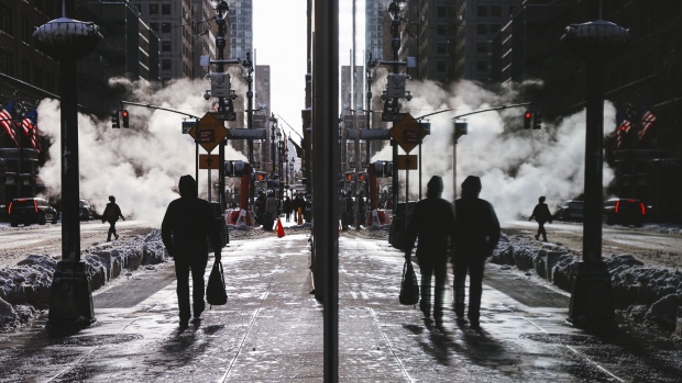 Pedestrians walk on a street after a winter storm in New York, U.S., on Thursday, Dec. 17, 2020. Winter Storm Gail pounded the city as temperatures dropped to 27 degrees with frigid sustained winds up to 35 mph, making dining outdoors unbearable amid the Covid-19 pandemic that has already crippled the restaurant industry. Photographer: Angus Mordant/Bloomberg