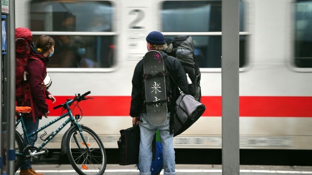 Travelers wait for a Deutsche Bahn AG passenger train to pull into a platform at Munich Central Station in Munich, Germany, on Tuesday, Jan. 5, 2021. Germany is poised to extend stricter lockdown measures beyond Jan. 10 amid criticism over alleged failures in the government’s fledgling vaccination program.