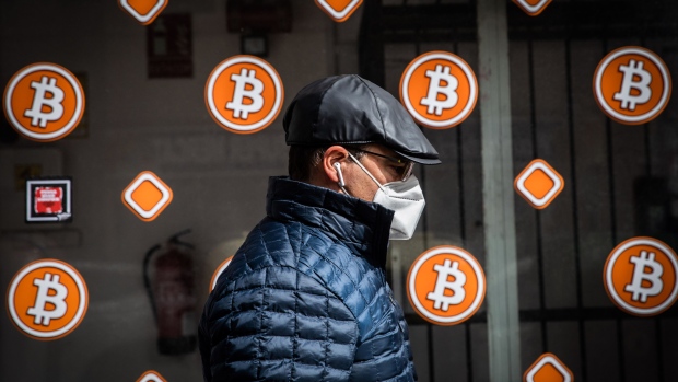 A pedestrian wearing a protective face mask passes a bitcoin automated teller machine (ATM) kiosk in Barcelona, Spain, on Tuesday, Feb. 23, 2021. Bitcoin climbed, aided by supportive comments from Ark Investment Management’s Cathie Wood and news that Square Inc. boosted its stake in the cryptocurrency. Photographer: Angel Garcia/Bloomberg