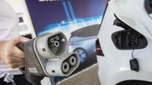 An employee holds a charger for a VW E-Golf at an electric charging station in front of the Volkswagen AG automobile manufacturing plant in Zwickau, Germany, on Monday, June 17, 2019. VW will spend 1.2 billion ($1.4 billion) retooling Zwickau to make a half-dozen electric models by 2021 but it warns that the payroll is likely to shrink. Photographer: Alex Kraus/Bloomberg