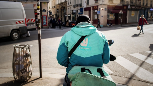 A Deliveroo delivery rider waits for customer orders on Rue de Buci, off Rue de Rennes in Paris, France, on Wednesday, Feb. 24, 2021. French President Emmanuel Macron’s approval rating was nearly steady in February as the country braces for announcements on new measures to curb the coronavirus pandemic. Photographer: Benjamin Girette/Bloomberg