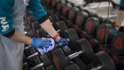 An employee cleans an dumbbell weights at a Pure Gym Group Plc health club, as they prepare for reopening from July 25, in the City of London, U.K., on Monday, July 20, 2020. U.K. Prime Minister Boris Johnson nudged Britons back to their office desks in an effort to revive the U.K.'s coronavirus-battered economy that risks putting him at odds with his own top scientific adviser. Photographer: Jason Alden/Bloomberg