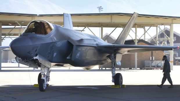 A fighter pilot sits in the cockpit while a crew member checks the exterior of a Lockheed Martin Corp. F-35A jet before a training flight in Hill Air Force Base, Utah, U.S., on Friday, Oct. 21, 2016. Lockheed Martin Corp.'s accelerating revenue growth outlook is boosted by its recent portfolio moves, which are enabling the world's largest defense contractor to better capitalize on higher foreign demand. Rising F-35 production is a key driver, as deliveries are to double by 2019 vs. current levels.