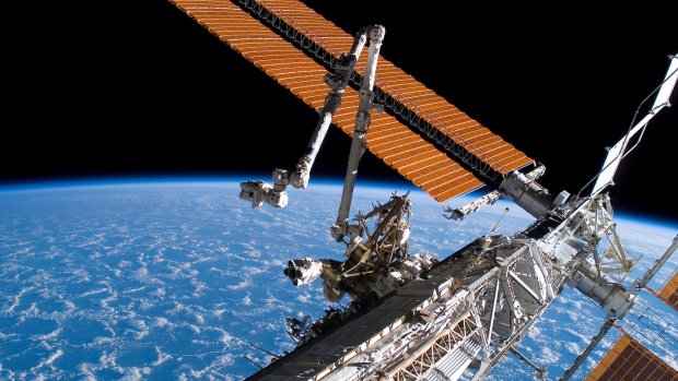 In this handout photo provided by NASA, the Canadarm2 (center) and solar array panel wings on the International Space Station are extended during the mission's first planned session of extravehicular activity (EVA) while Space Shuttle Endeavour (STS-118) was docked with the International Space Station August 11, 2007 in Space. 