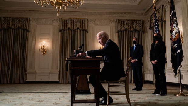 WASHINGTON, DC - JANUARY 27: U.S. President Joe Biden signs executive orders after speaking about climate change issues in the State Dining Room of the White House on January 27, 2021 in Washington, DC. President Biden signed several executive orders related to the climate change crisis on Wednesday, including one directing a pause on new oil and natural gas leases on public lands. Also pictured, left to right, Special Presidential Envoy for Climate John Kerry and U.S. Vice President Kamala Harris. (Photo by Anna Moneymaker-Pool/Getty Images)