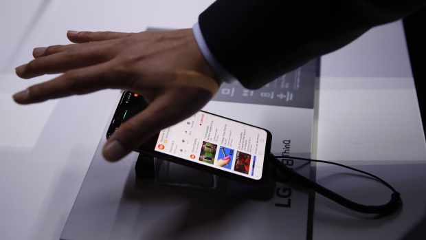 An attendee demonstrates the hand gesture features of a G8 ThinQ smartphone on display during an LG Electronics Inc. launch event ahead of the MWC Barcelona in Barcelona, Spain, on Sunday, Feb. 24, 2019. At the wireless industry’s biggest conference, over 100,000 people are set to see the latest innovations in smartphones, artificial intelligence devices and autonomous drones exhibited by more than 2,400 companies. Photographer: Stefan Wermuth/Bloomberg