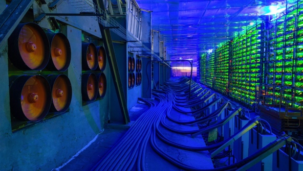 Industrial cooling fans operate to thermally regulate illuminated mining rigs at the CryptoUniverse cryptocurrency mining farm in Nadvoitsy, Russia, on Thursday, March 18, 2021. The rise of Bitcoin and other cryptocurrencies has prompted the greatest push yet among central banks to develop their own digital currencies. Photographer: Andrey Rudakov/Bloomberg