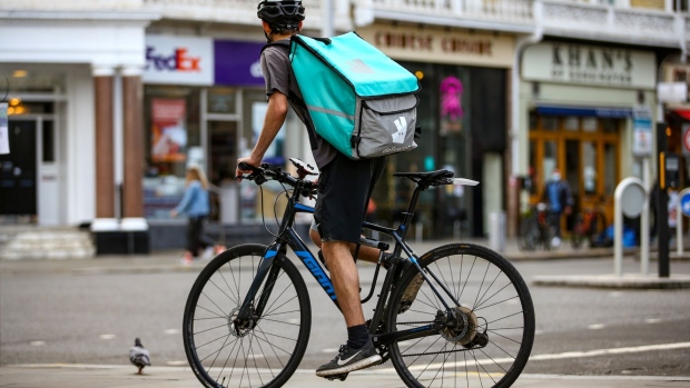 A takeaway food courier, working for Deliveroo, operated by Roofoods Ltd., cycles in the South Kensington district of London, U.K., on Tuesday, Sept. 29, 2020. Covid-19 lockdown enabled online and app-based grocery delivery service providers to make inroads with customers they had previously struggled to recruit, according the Consumer Radar report by BloombergNEF.