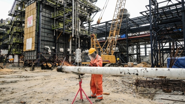 A worker wearing a face shield cuts metal pipework at the under-construction Dangote Industries Ltd. oil refinery and fertilizer plant site in the Ibeju Lekki district, outside of Lagos, Nigeria, on Friday, March 6, 2020. Aliko Dangote, Africa’s richest man, plans to spend more than his net worth of $13.5 billion building one of the world’s biggest oil refineries. Photographer: Tom Saater/Bloomberg