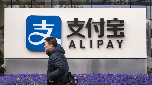 A pedestrian walks past an Alipay sign outside an Ant Group Co. office building in Shanghai, China, on Thursday, Dec. 24, 2020. China kicked off an investigation into alleged monopolistic practices at Alibaba Group Holding Ltd. and summoned affiliate Ant Group to a high-level meeting over financial regulations, escalating scrutiny over the twin pillars of billionaire Jack Ma’s internet empire. Photographer: Qilai Shen/Bloomberg