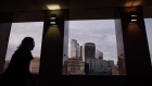A pedestrian passes skyscrapers in the skyline of the City of London, U.K., on Monday, March 8, 2021.